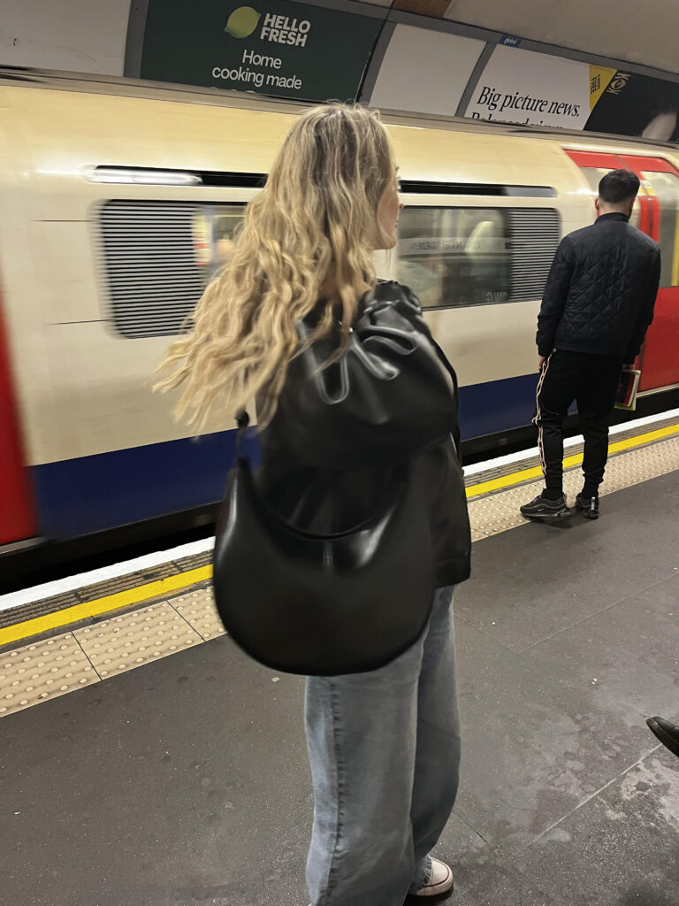 Blonde girl on the tube posing on the London underground with a leather bag