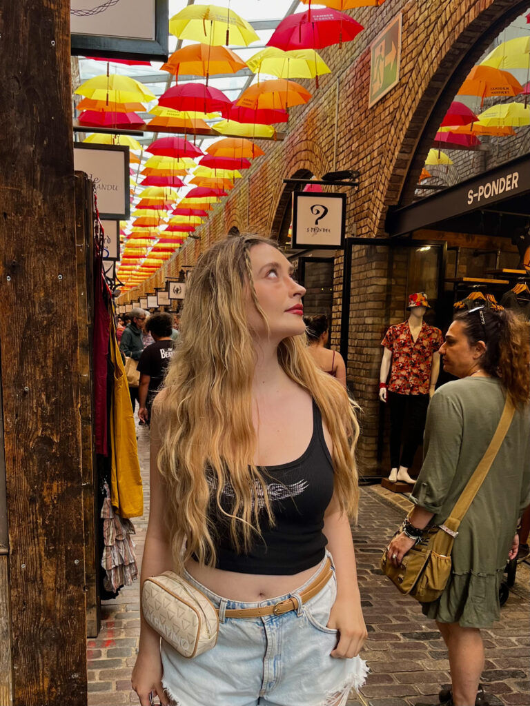 Instagram photo idea in camden market with bright coloured umbrella in the rain