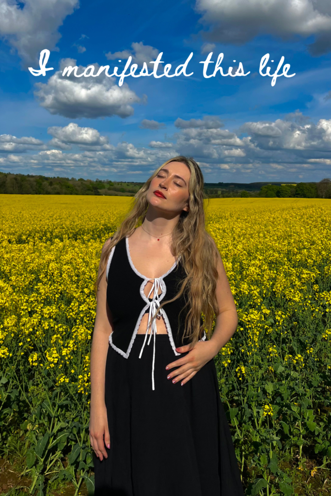 blonde woman in yellow flower field in Cotswolds with blue sky 