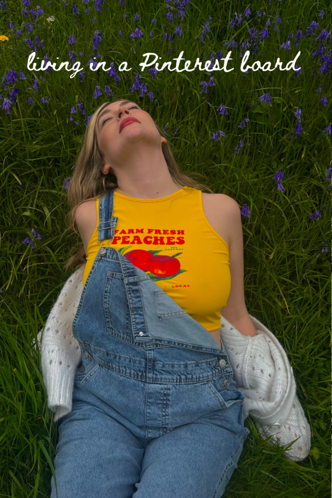 blonde woman in dungarees laying in bluebells grass in summer 