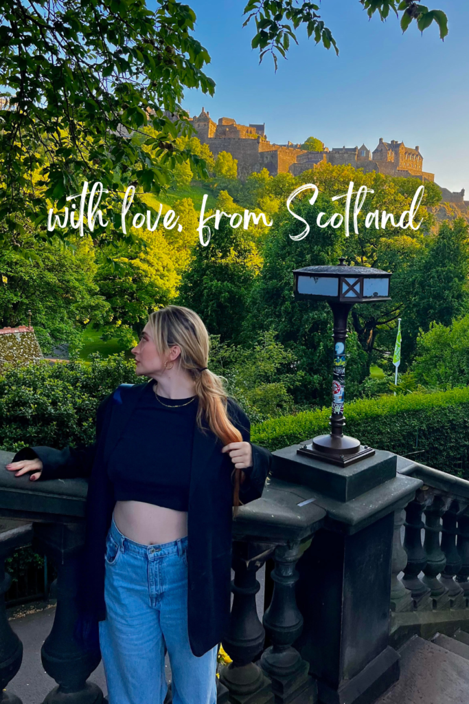 woman stood in black in Princes Street Gardens with Edinburgh Castle in background