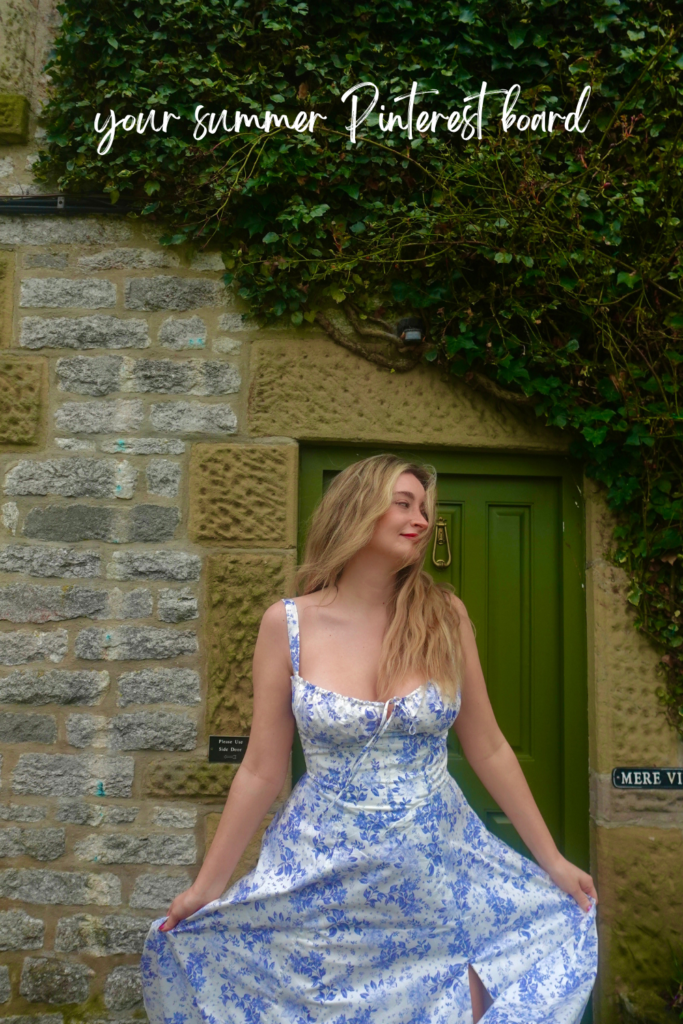 blonde woman in long dress stands outside a country cottage with a green door and ivy covered walls